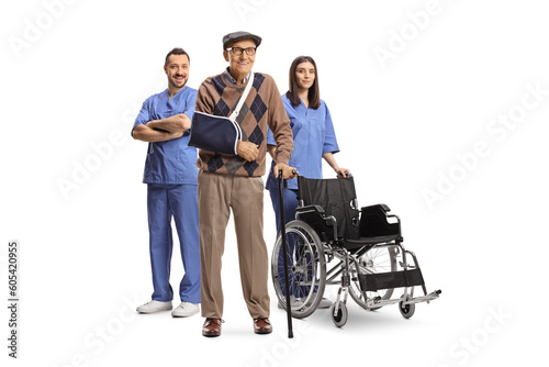 Male and female nurse with a wheelchair standing behind an elderly injured male patient © Ljupco Smokovski