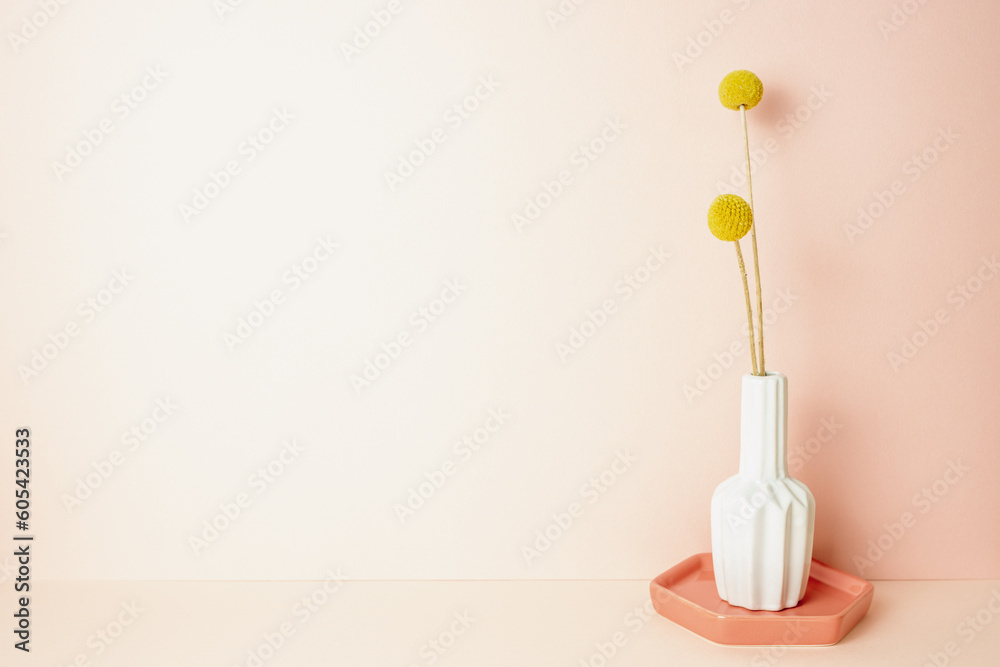 Vase of yellow craspedia golden ball flower on pink table. pink wall background. copy space
