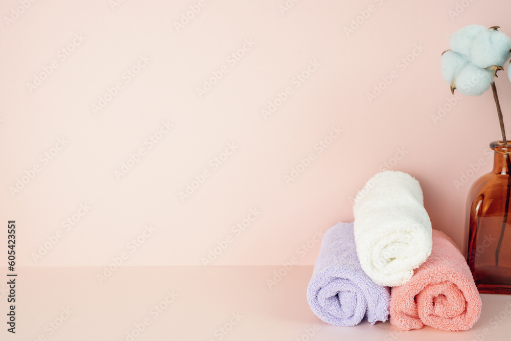 Bathroom soft clean towel with vase of cotton flower on pink table. pink wall background. copy space