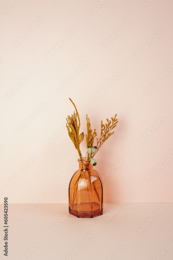 Brown glass vase of dry flower on pink table. pink wall background. copy space
