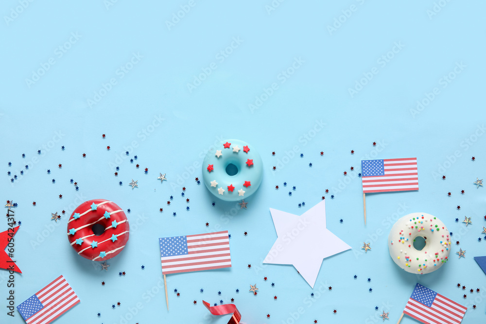 Obraz premium Composition with donuts, USA flags and confetti on blue background. Independence Day celebration