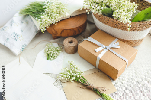 Festive concept, lily of the valley bouquet, gift box and letter
