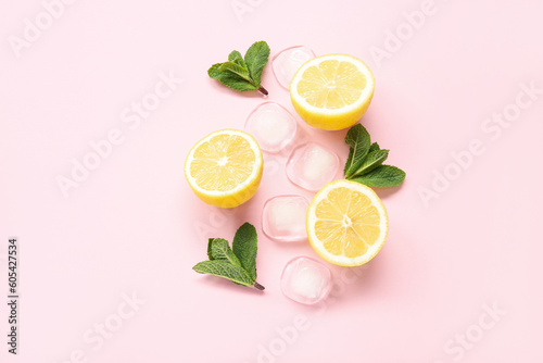 Slices of ripe lemon with mint and ice cubes on pink background