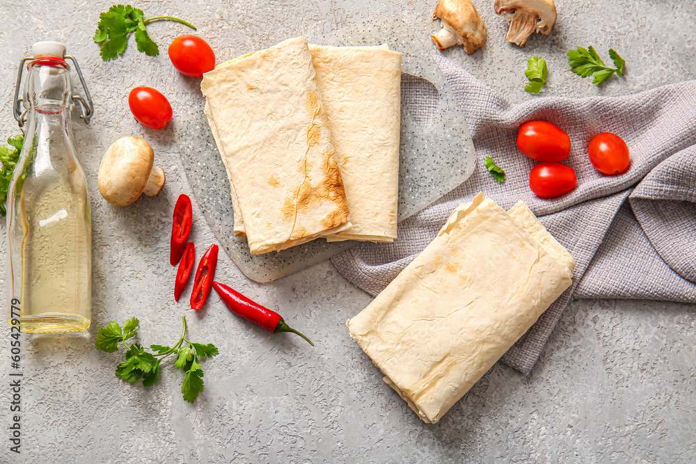 Board with lavash and fresh vegetables on grey background Board with lavash and fresh vegetables on grey background