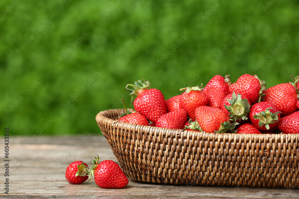 Wicker bowl with fresh strawberry on wooden table outdoors Wicker bowl with fresh strawberry on wooden table outdoors