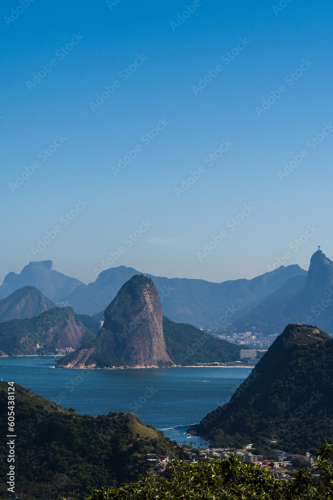Beautiful view of Rio de Janeiro, Brazil seen from Niterói. With many hills in the background, Guanabara Bay, Jujuruba, Sugarloaf Mountain, Christ the Redeemer, beaches, pier with boats. Sunny day