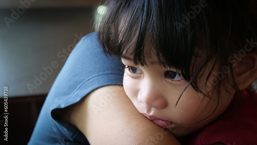 Sad Little Girl is crying in the arms of his mother. Mother and baby with tears in their eyes emotionally embrace. A loving mother hugs and comforts her little daughter. Mom calms child.