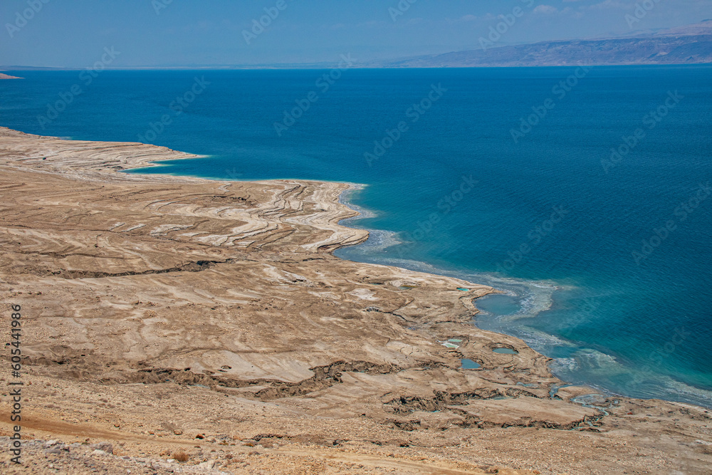 Drying of the Dead Sea, located at the lowest point of the Earth. The water recedes, leaving behind a desolate landscape and barren land.