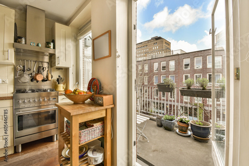 a kitchen with an open door that leads out to the patio area and balcony overlooking the cityscapea photo