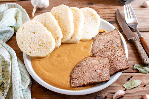 Typical Czech food svickova with beef slices, cream sauce and bread dumplings on the table