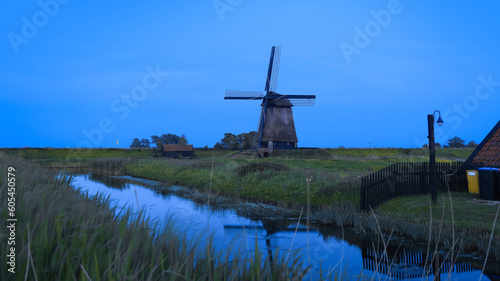 Ondermolen D windmill near Schermerhorn city in Netherlands during twilight.