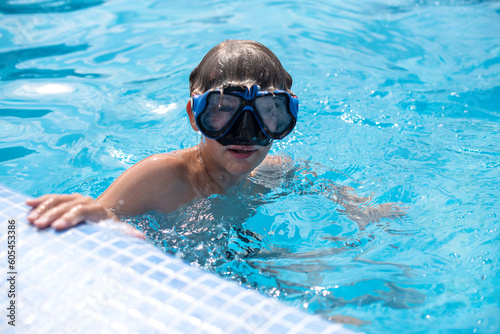 Underwater teen boy in the swimming pool with goggles in sunny day. Children Summer Fun, holidays, weekends