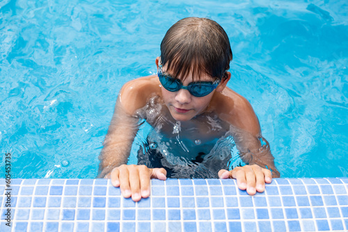 Underwater teen  boy  in the swimming pool with goggles in sunny day.  Children Summer Fun, holidays, weekends