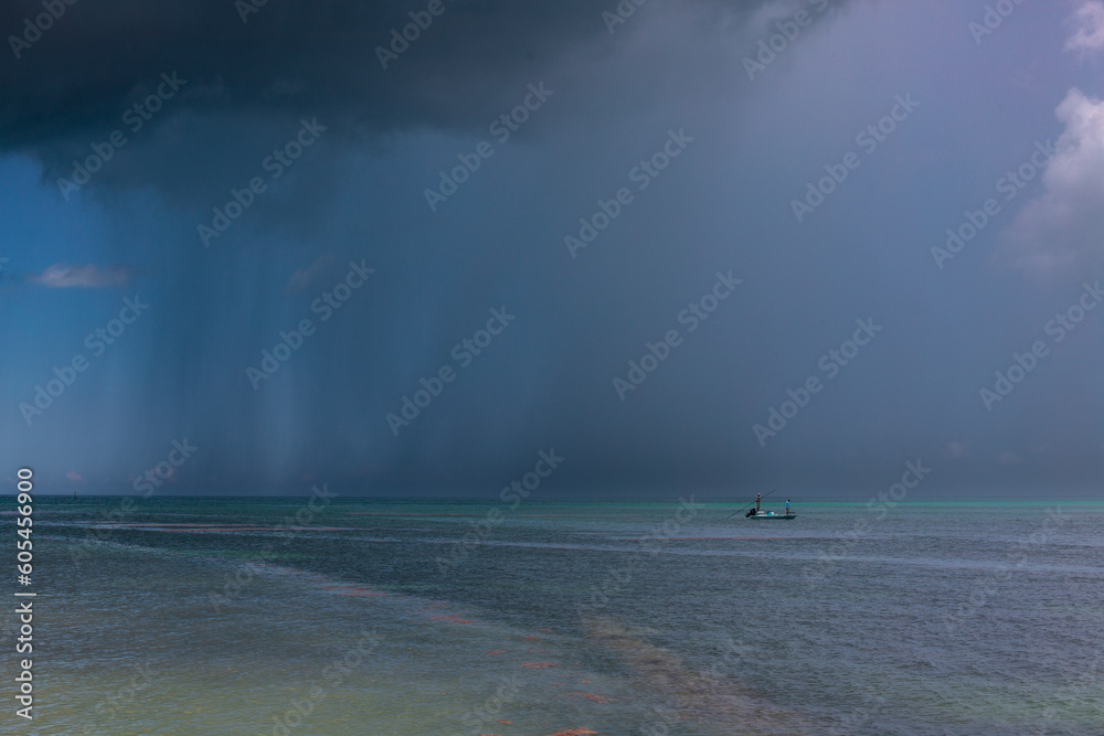 petite barque de pêcheurs dans la mer des Caraïbes sous une averse tropicale petite barque de pêcheurs dans la mer des Caraïbes sous une averse tropicale