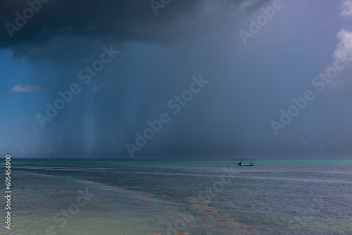 petite barque de pêcheurs dans la mer des Caraïbes sous une averse tropicale photo