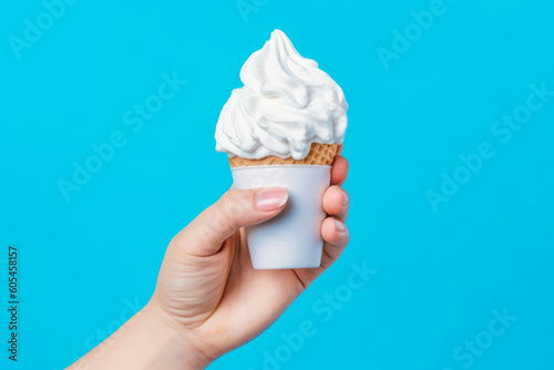 hand holding a waffle cone with white ice cream on a blue background, Generative AI