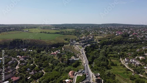 Aerial view of Kamianets-Podilsky historic fortress castle and canyon of the Smotrych River, Novoplanivskyi Bridge in Ukraine. Medieval castle with impenetrable walls, towers and battlements photo