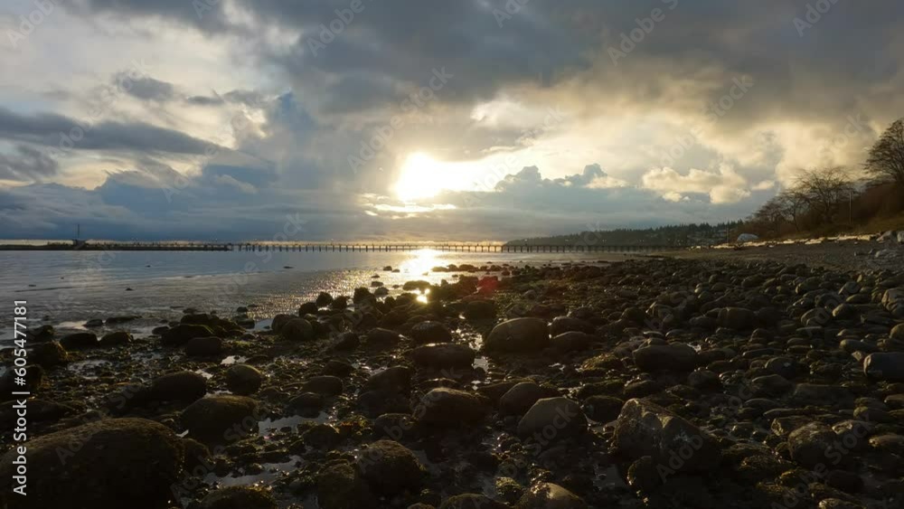 Rocky Beach and White Rock Pier on the West Coast of Pacific Ocean. Dramatic Cloudy Sunset Sky. Vancouver, British Columbia, Canada. Rocky Beach and White Rock Pier on the West Coast of Pacific Ocean. Dramatic Cloudy Sunset Sky. Vancouver, British Columbia, Canada.