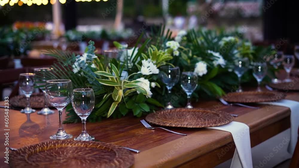 Una Mesa de Eventos que Refleja la Excelencia con flores, copas y platoa