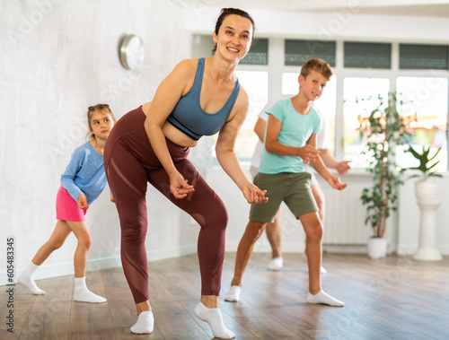 Family with two children engaged in active dancing in fitness studio