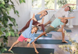 Parents with daughter and son practice pilates exercises in fitness class
