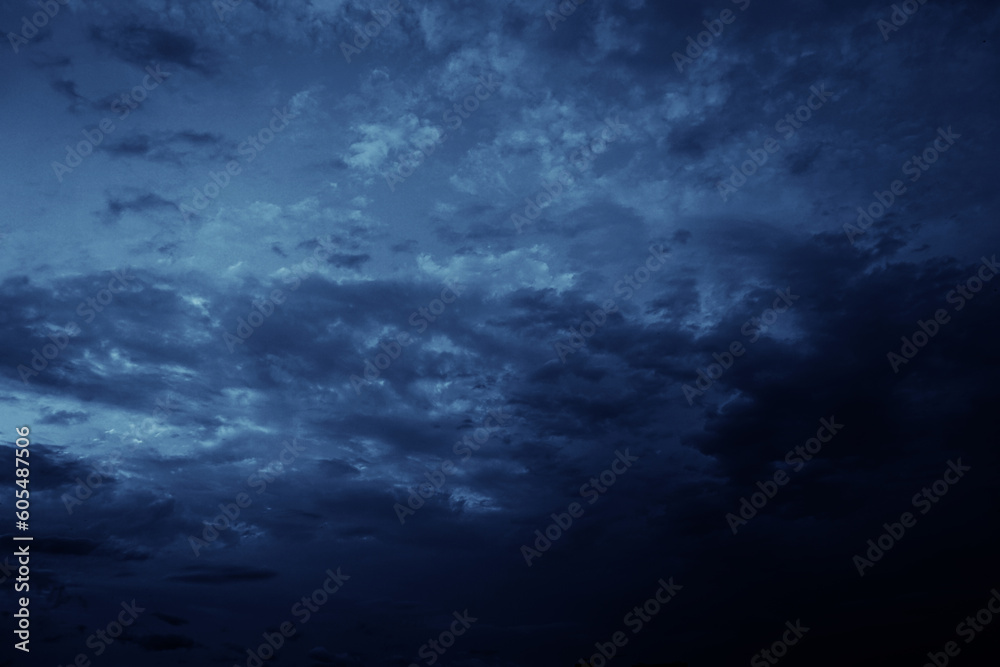 Black blue evening night sky with clouds. Dark dramatic sky background. Before the storm, thunderstorm, rain. Frightening, ominous, moody, creepy atmosphere.
