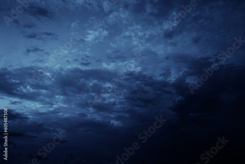 Black blue evening night sky with clouds. Dark dramatic sky background. Before the storm, thunderstorm, rain. Frightening, ominous, moody, creepy atmosphere.