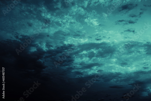 Black blue green teal night sky with clouds. Storm  wind  rain. Dramatic dark skies background. Glow  light  lightning. Magical  mystical  ominous  frightening  spooky  fantasy  fantastic heaven.