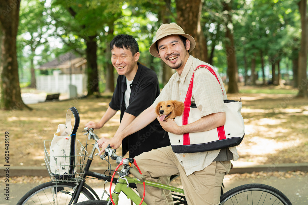 Obraz premium 飼い犬を連れて自転車で公園に来た男性2人組
