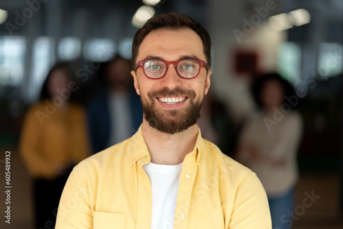 Confident Caucasian man, manager wearing trendy glasses, smiling looking confidently at camera.