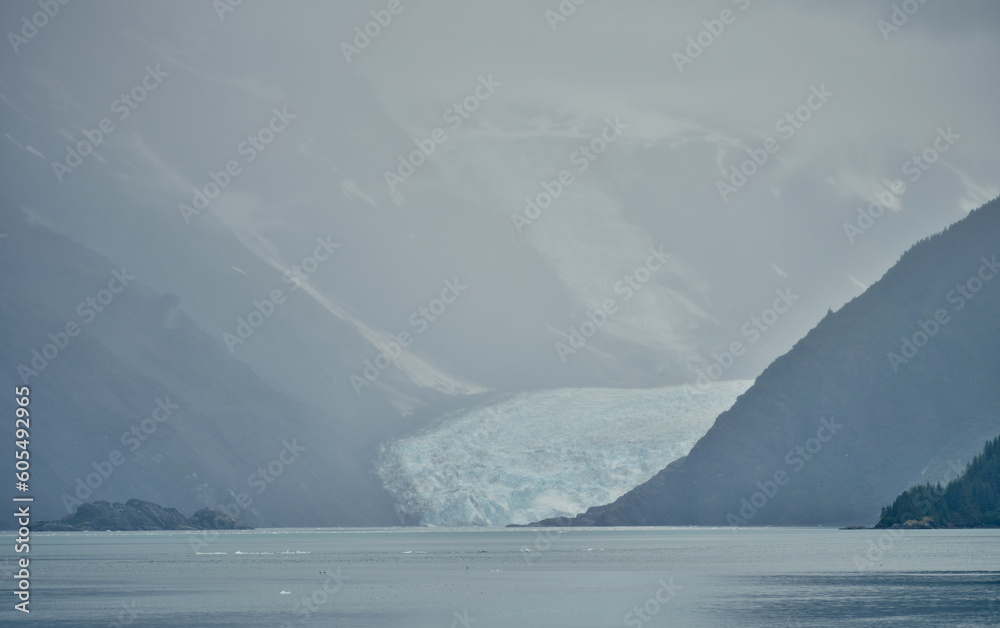 Approaching one of many glaciers coming down from the mountains in the Fog and mist in Prince William Sound near Whittier Alaska