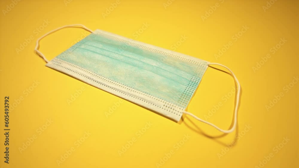 light blue protective mask on bright yellow color background light blue protective mask on bright yellow color background
