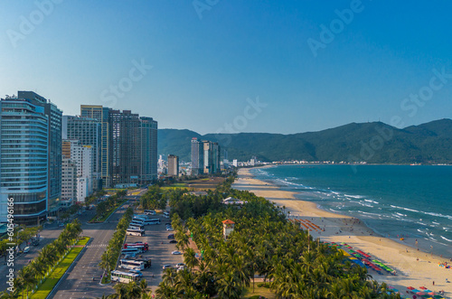 Aerial sunset view of Da Nang coastline. My Khe beach seafront with high-rise hotels and skyscrapers in the golden sand beach