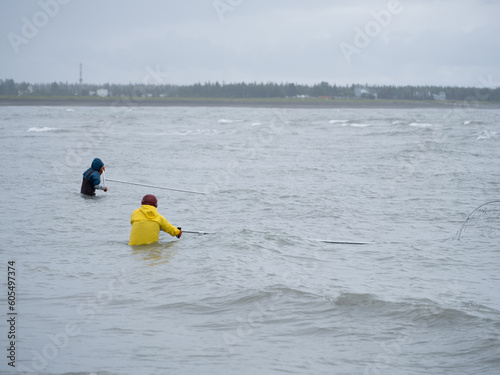 Yellow rain suit clad fisherman dip netting for salmon on the Kenai Peninsula Alaska during the annual Native Alaskan Dip Netting season
