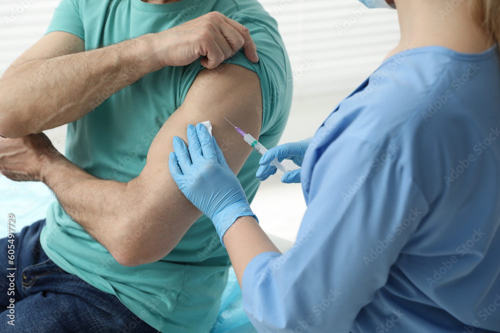 Doctor giving hepatitis vaccine to patient in clinic, closeup Doctor giving hepatitis vaccine to patient in clinic, closeup