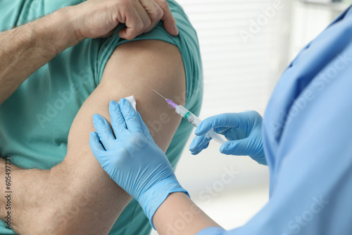 Doctor giving hepatitis vaccine to patient in clinic  closeup