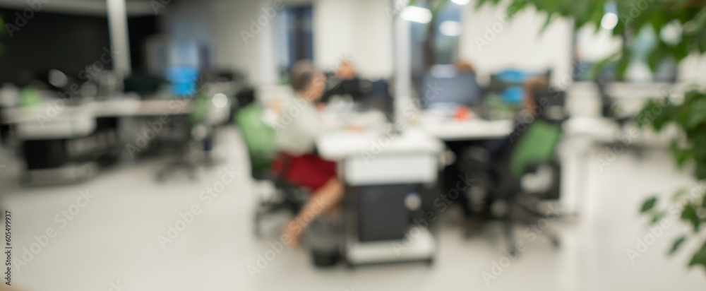 Fototapeta premium Blurry photo. Four colleagues at their desks. 