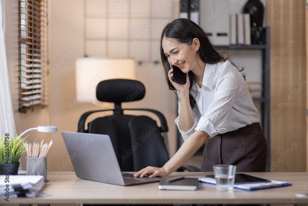 Happy caucasian young Asian woman using smart phone cellphone for calls, social media, mobile application online in office money financial planning Business And Education Concept. Happy caucasian young Asian woman using smart phone cellphone for calls, social media, mobile application online in office money financial planning Business And Education Concept.