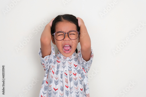 Asian little girl grabbing her hari and scream showing stressed expression