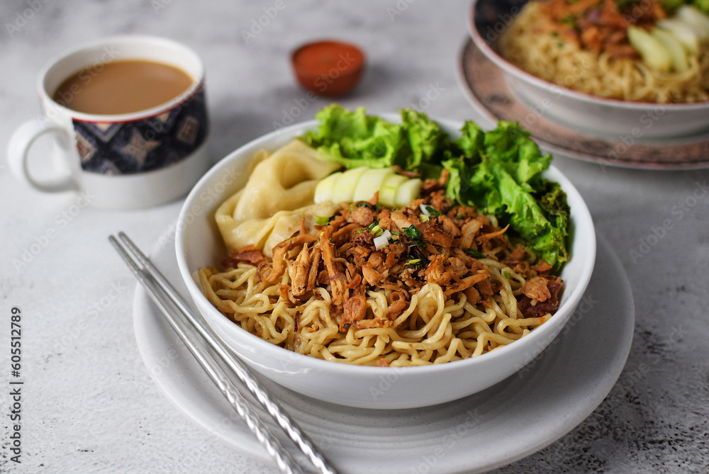 Mie ayam, noodles with chicken and vegetables, Indonesian traditional food in grey texture background. Mie ayam, noodles with chicken and vegetables, Indonesian traditional food in grey texture background.