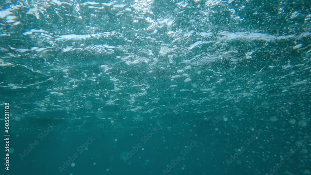 Air bubbles in clean blue ocean water, underwater pov shot of a