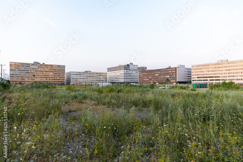 vue sur un terrain vague dans un quartier industriel avec des bâtiments à étages en arrière plan