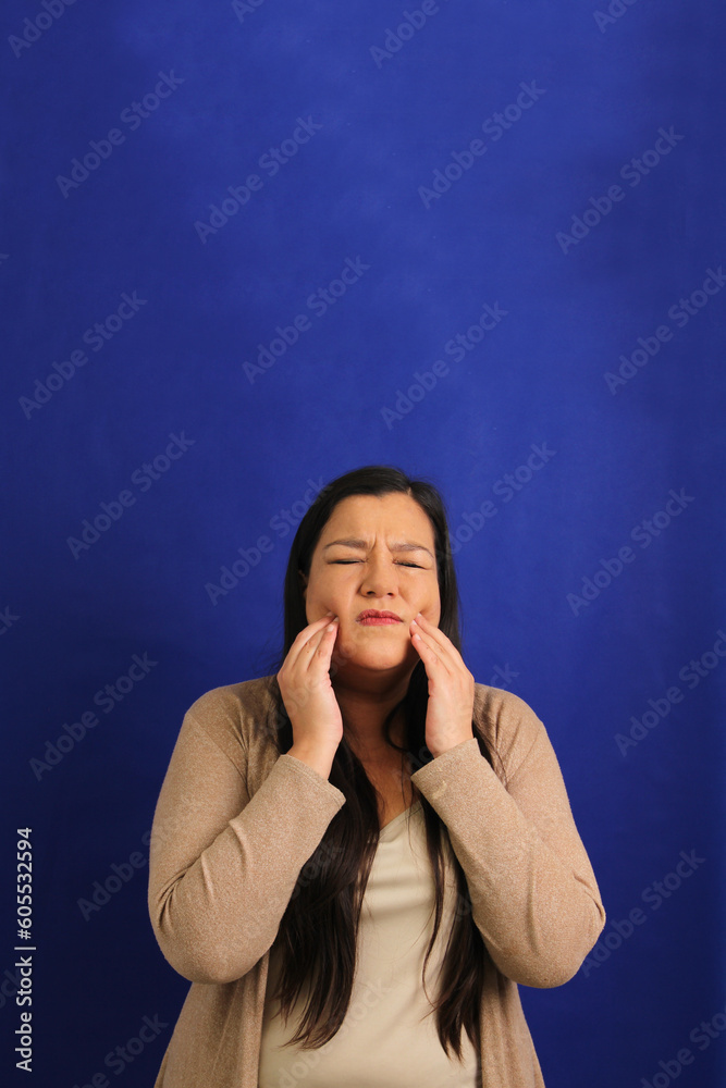 Adult 40-year-old Latina woman suffers pain in her teeth due to cavities and gingivitis, she urgently needs a visit to the dentist Adult 40-year-old Latina woman suffers pain in her teeth due to cavities and gingivitis, she urgently needs a visit to the dentist