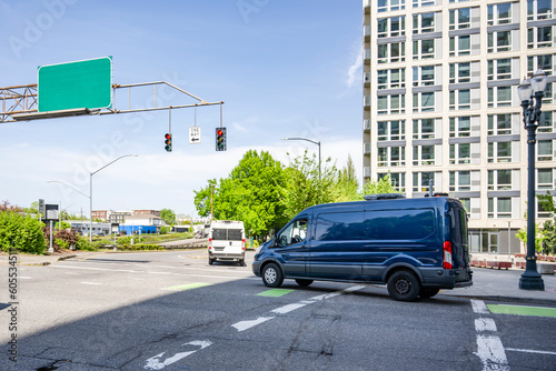 Wallpaper Mural Commercial cargo mini vans making deliveries driving on the city crossroad with traffic light Torontodigital.ca