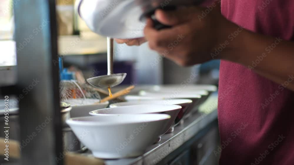 Preparing chicken noodles. View of a penjual mie ayam bakso or meatball chicken noodle seller who is making chicken noodles for the buyer. Selective focus. Preparing chicken noodles. View of a penjual mie ayam bakso or meatball chicken noodle seller who is making chicken noodles for the buyer. Selective focus.
