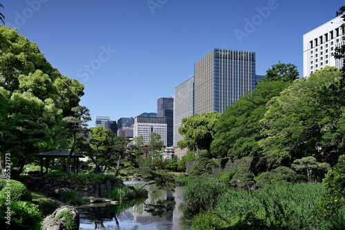 Looking at high-rise office buildings in Hibiya Marunouchi from Shinji Pond, Hibiya Park, Tokyo. Taken May 2023.