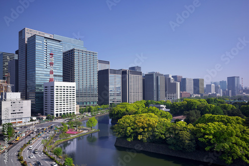 April 2023 Tokyo in the fresh greenery, beyond the moat of the Imperial Palace, high-rise office buildings in Otemachi and Marunouchi line up. photo
