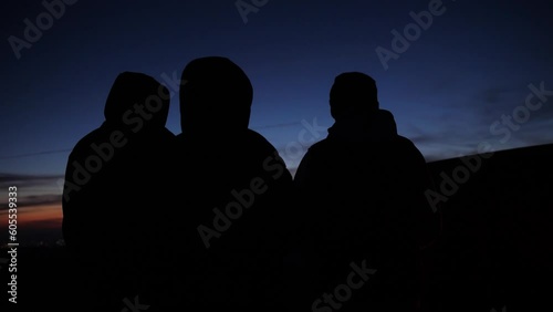 Slow motion of three friends socializing outdoors during a camping trip.