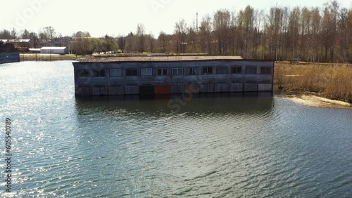 Static front view of rusted boat garages on lake near forest edge photo