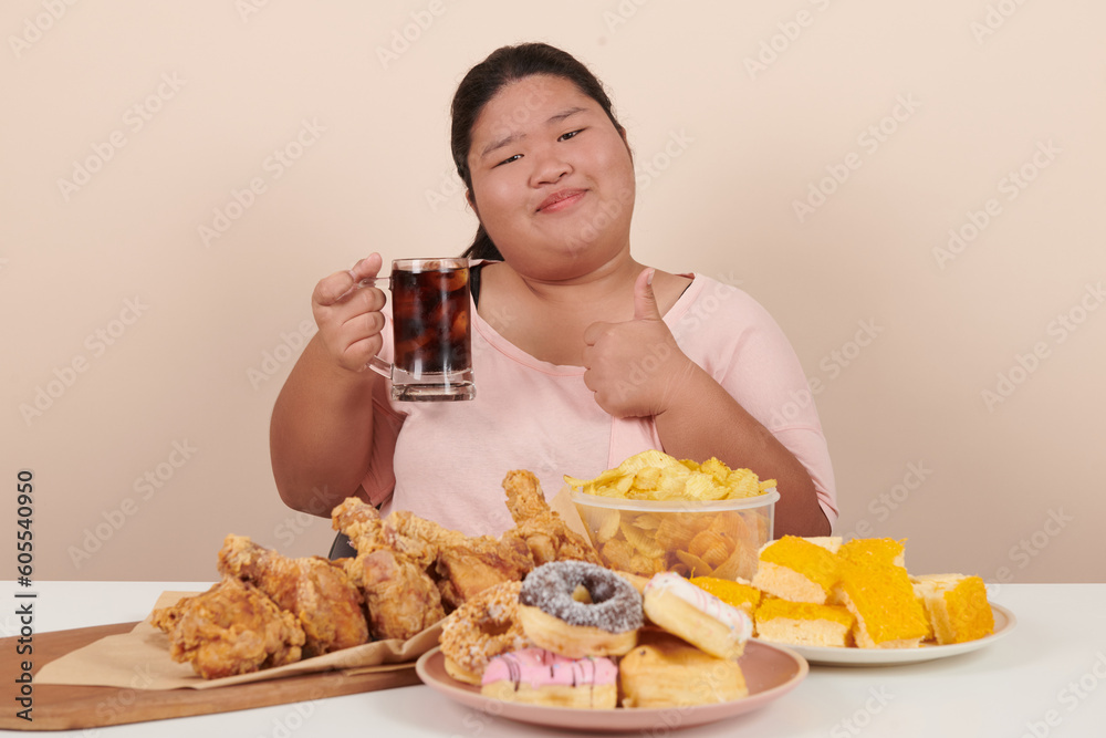 obesity young women binge eating disorder concept with woman eating fast food burger, fired chicken , donuts and desserts, junk food, high calorie foods, overweight female have unhealthy lifestyle. obesity young women binge eating disorder concept with woman eating fast food burger, fired chicken , donuts and desserts, junk food, high calorie foods, overweight female have unhealthy lifestyle.